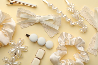 Different hair accessories on beige background, flat lay