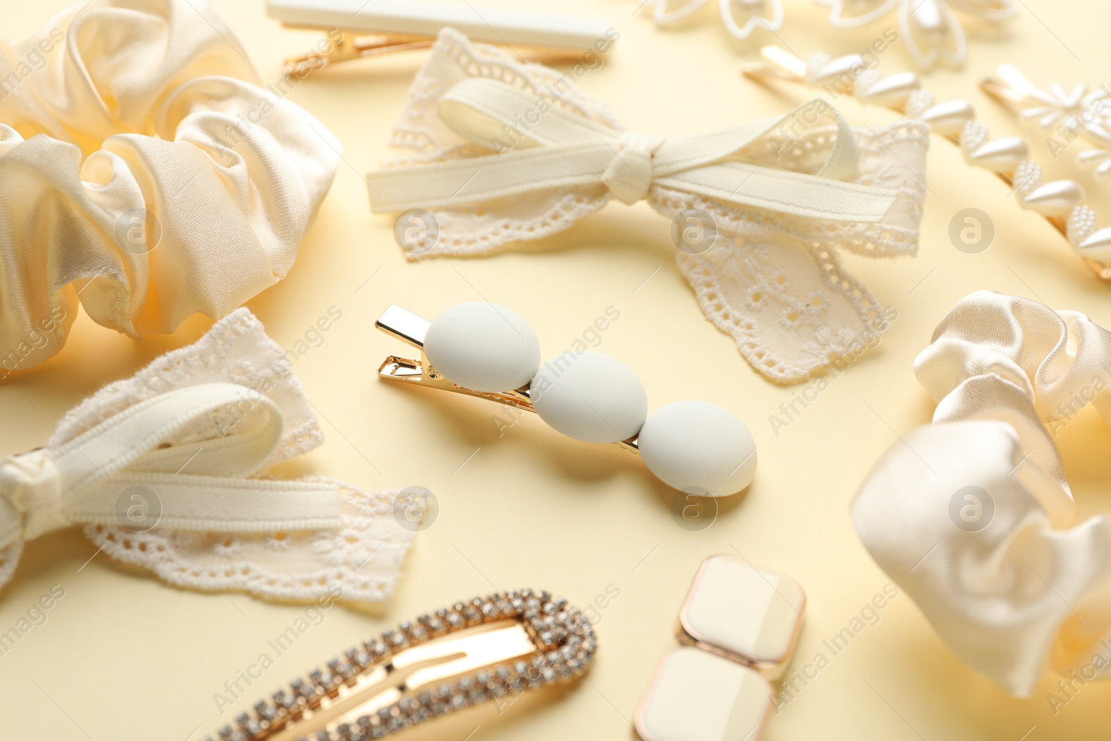 Photo of Different hair accessories on beige background, closeup