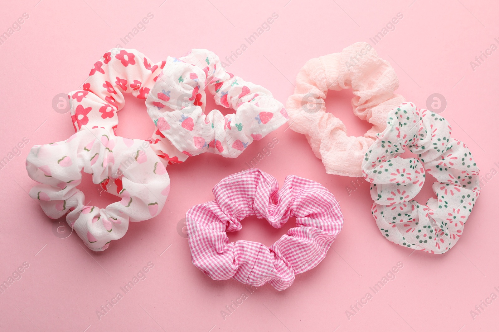 Photo of Different hair scrunchies on pink background, flat lay