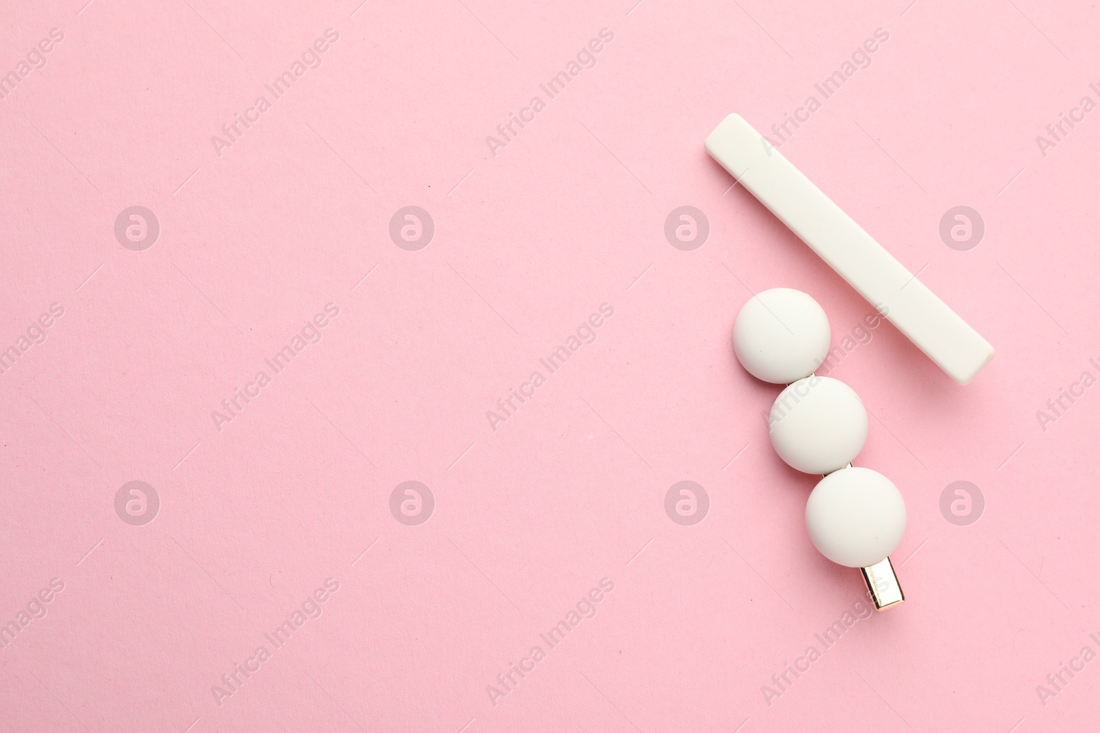 Photo of Beautiful hair clips on pink background, flat lay. Space for text