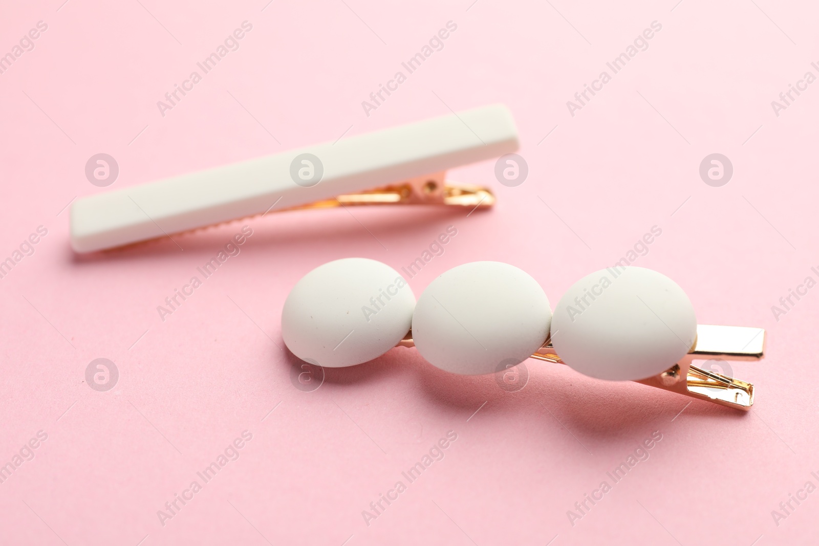 Photo of Beautiful hair clips on pink background, closeup