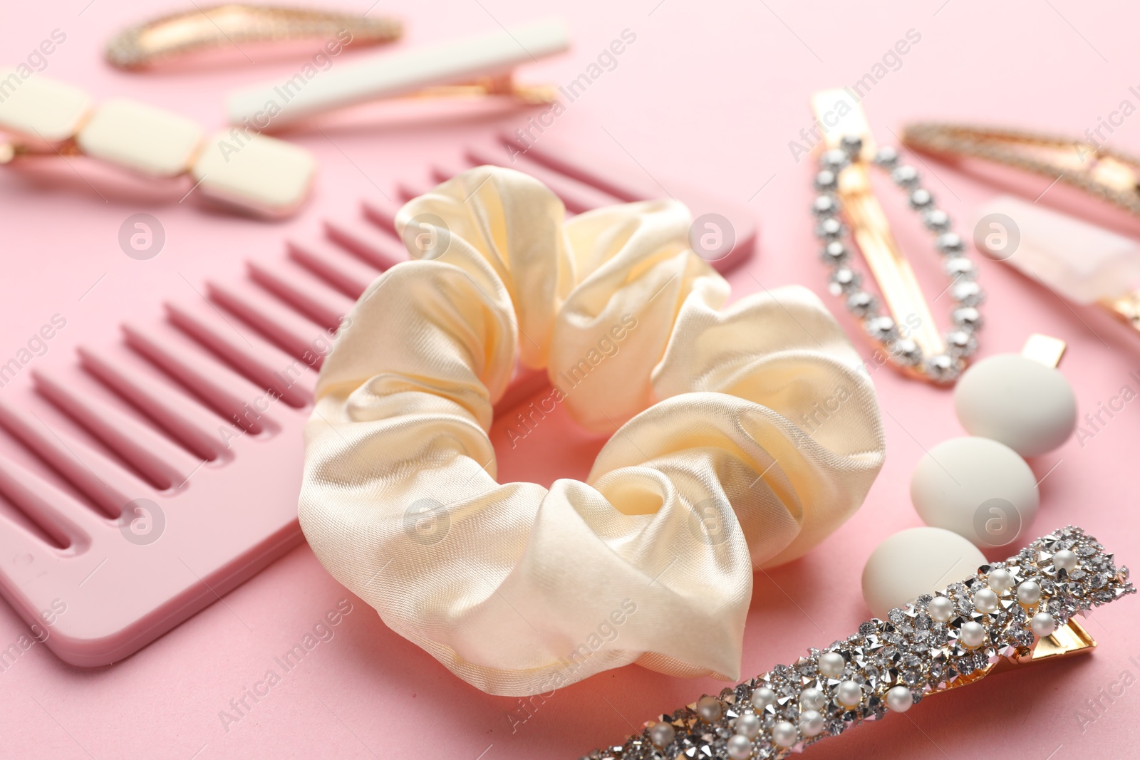 Photo of Different hair accessories on pink background, closeup