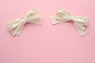 Photo of Beautiful hair bows on pink background, flat lay. Space for text