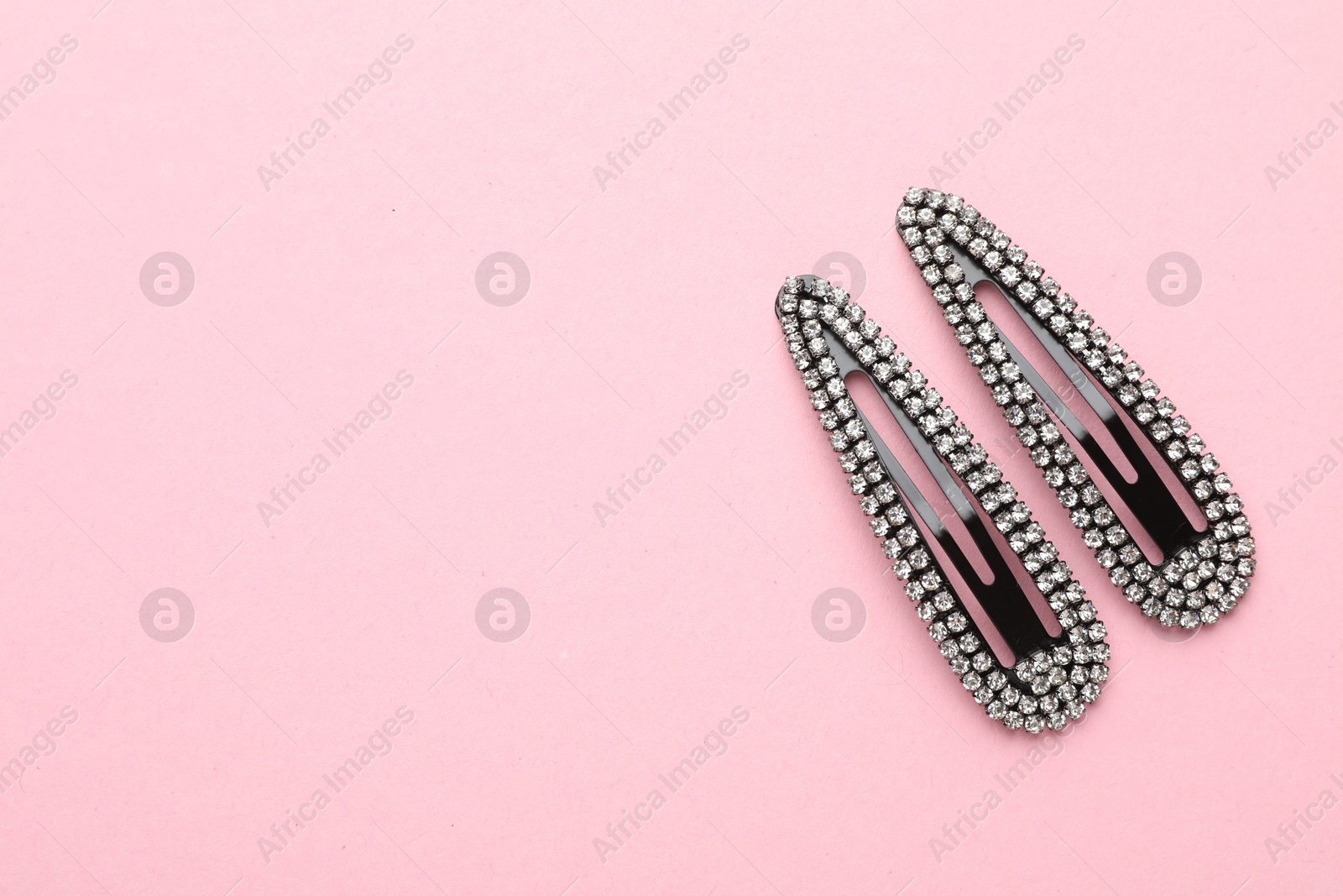 Photo of Beautiful hair clips on pink background, flat lay. Space for text