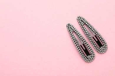 Beautiful hair clips on pink background, flat lay. Space for text