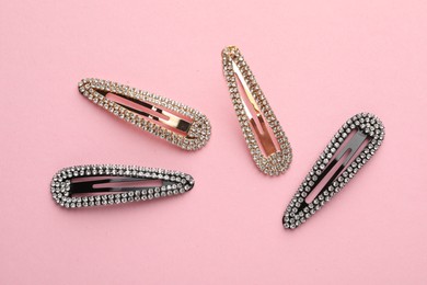 Photo of Different hair clips on pink background, flat lay