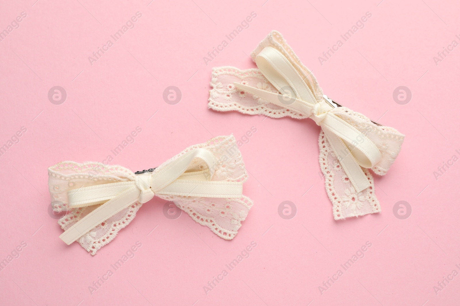 Photo of Beautiful hair bows on pink background, flat lay