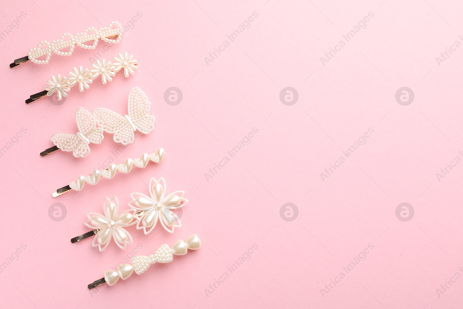 Photo of Different hair clips on pink background, flat lay. Space for text