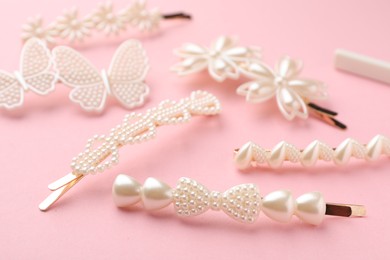 Photo of Different hair clips on pink background, closeup