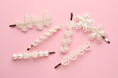 Photo of Different hair clips on pink background, flat lay