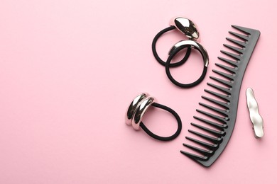 Different hair accessories on pink background, flat lay. Space for text