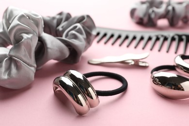 Photo of Different hair accessories on pink background, closeup