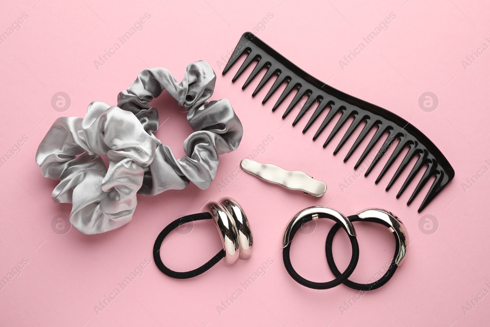 Photo of Different hair accessories on pink background, flat lay