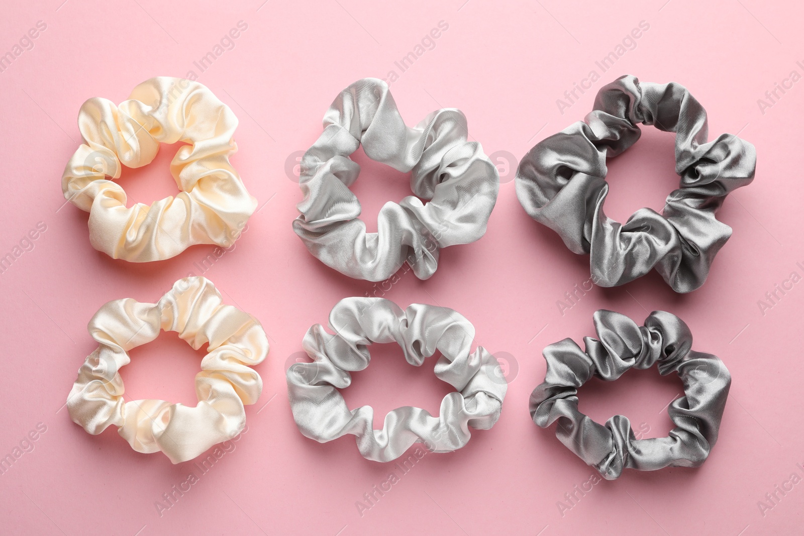 Photo of Different hair scrunchies on pink background, flat lay