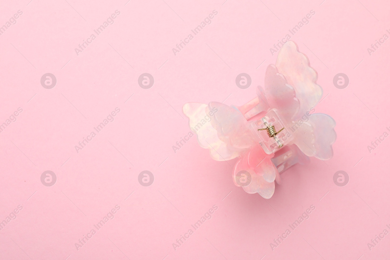 Photo of Beautiful hair clip on pink background, top view. Space for text