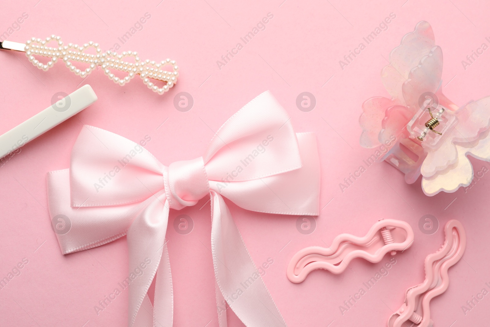 Photo of Different hair accessories on pink background, flat lay