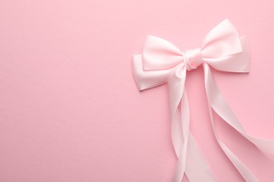 Photo of Hair bow on pink background, top view. Space for text