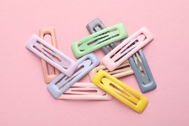 Photo of Different hair clips on pink background, flat lay