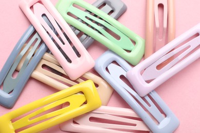 Photo of Different hair clips on pink background, flat lay