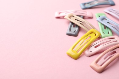 Different hair clips on pink background, closeup. Space for text