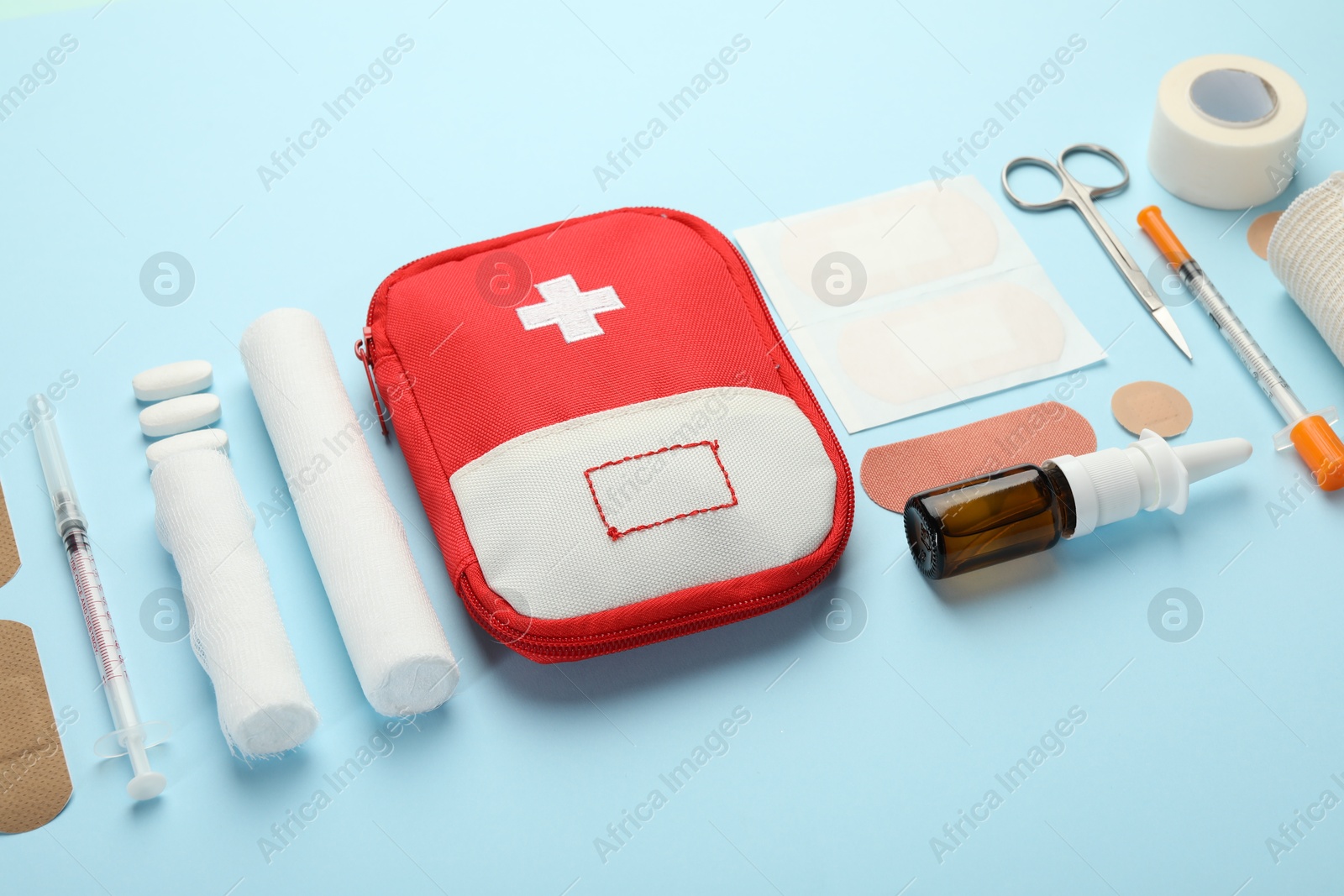 First aid kit. Different medical supplies on light blue background Photo of First aid kit. Different medical supplies on light blue background