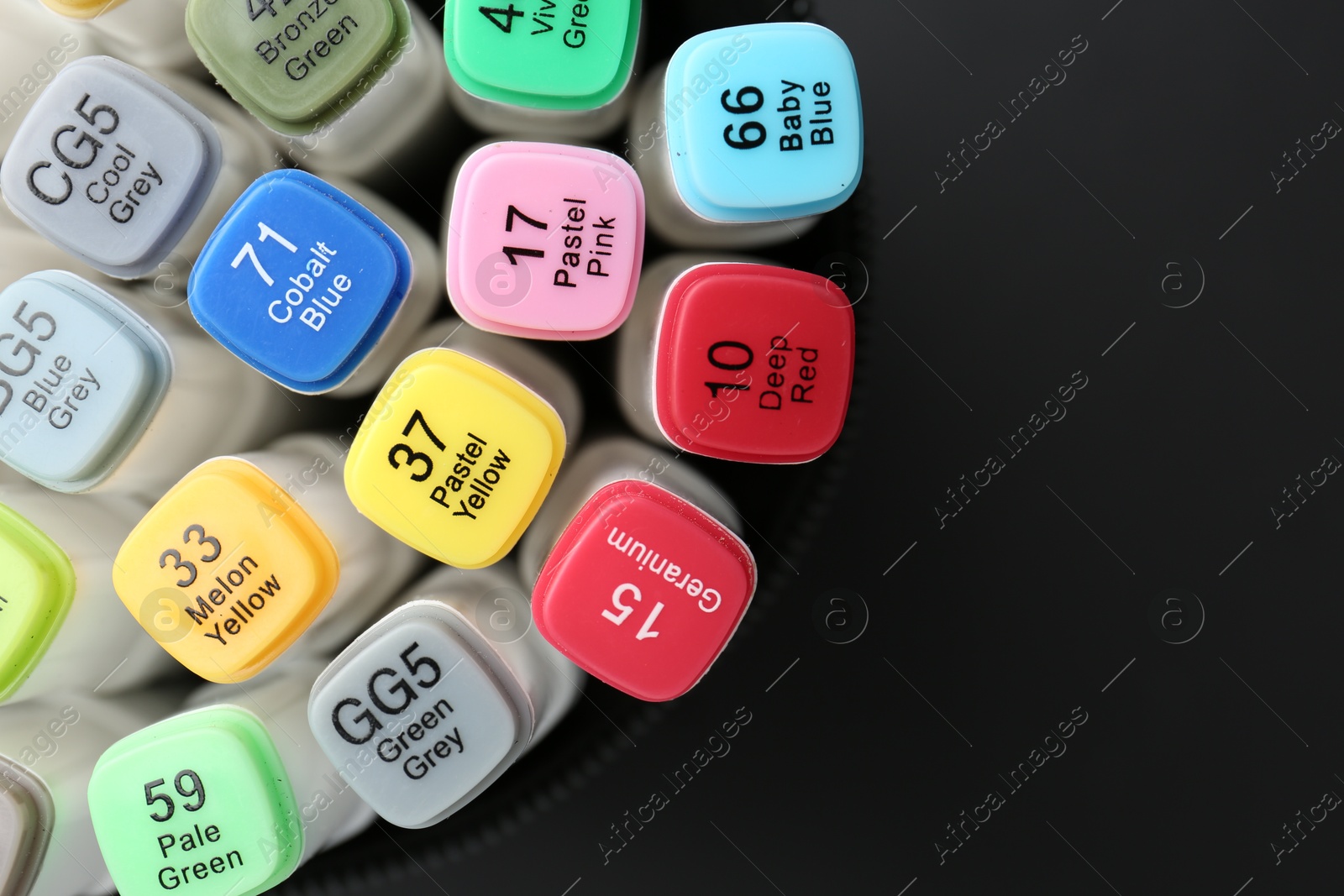 Photo of Many colorful marker pens in holder on black background, top view. Space for text