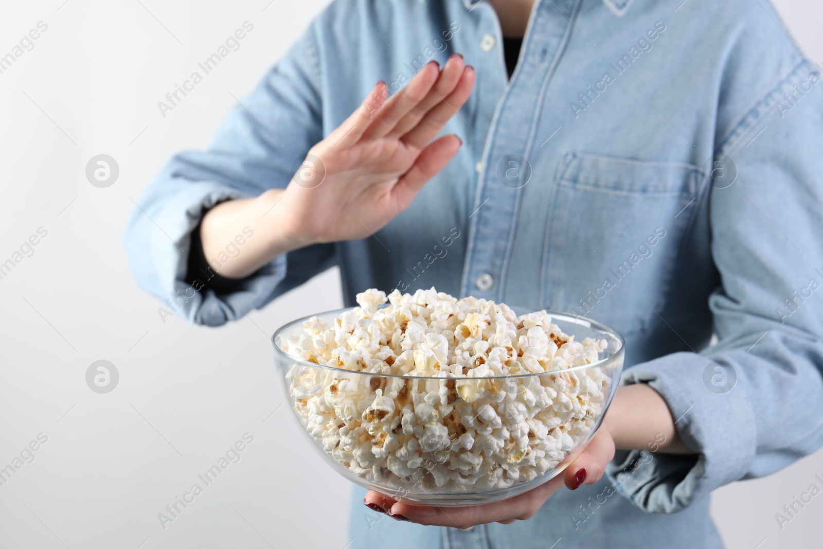 Photo of Woman refusing to eat popcorn on white background, closeup. Food allergy concept