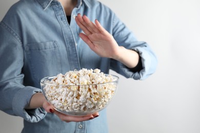 Photo of Woman refusing to eat popcorn on white background, closeup. Food allergy concept