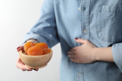 Photo of Woman refusing to eat dried apricots on white background, closeup. Food allergy concept