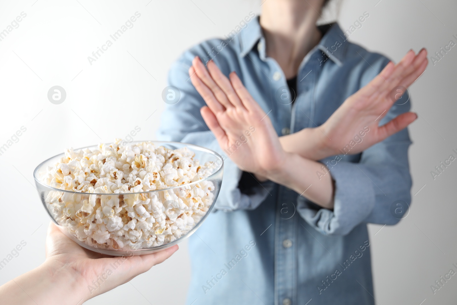 Photo of Woman refusing popcorn on white background, , selective focus. Food allergy concept