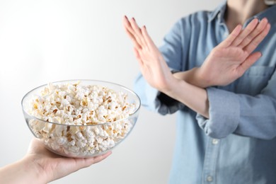 Photo of Woman refusing popcorn on white background, , selective focus. Food allergy concept