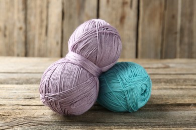 Photo of Skeins of colorful yarn on wooden table, closeup