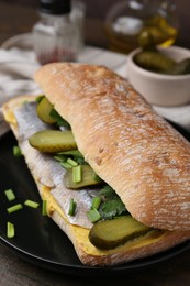 Photo of Tasty sandwich with herring, pickles, green onions and parsley on table, closeup