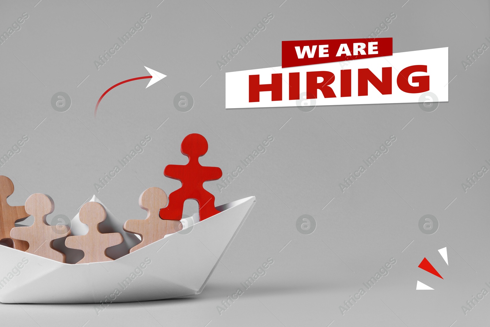 Image of We Are Hiring announcement. Red human figure among wooden ones in paper boat on grey background. Human resource