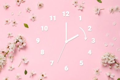 Image of Clock and flowers on pink background, top view. Arrow showing time change one hour ahead in spring. Daylight saving time