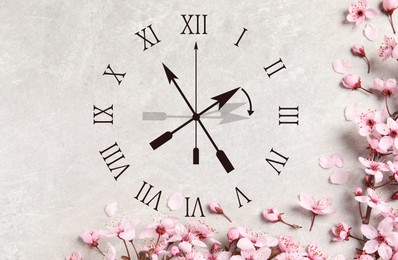 Image of Clock and pink flowers on grey background, top view. Arrow showing time change one hour ahead in spring. Daylight saving time