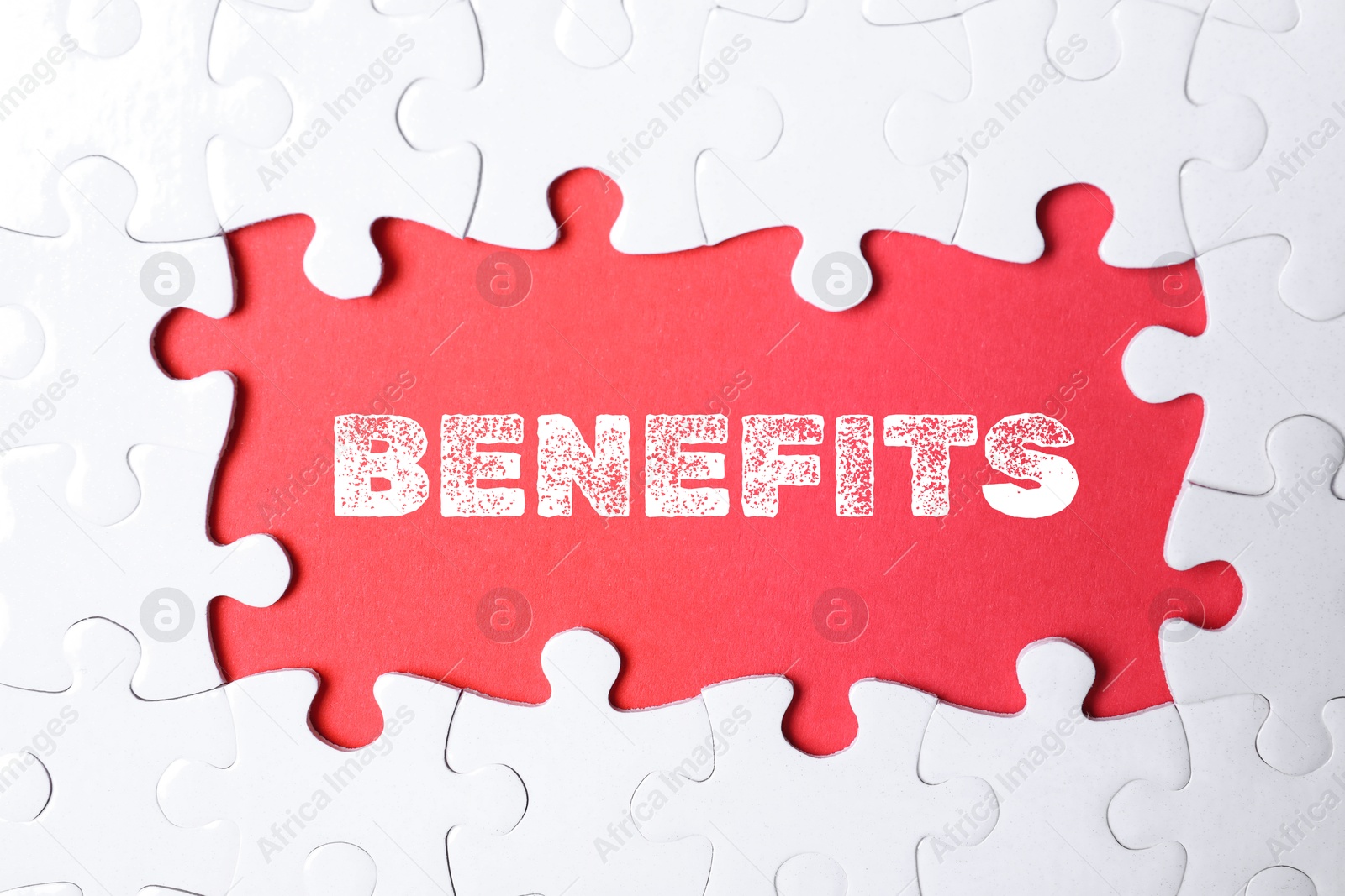 Image of Benefits word and white jigsaw puzzle pieces on red background, top view