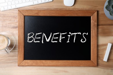 Image of Small chalkboard with word Benefits on wooden table, top view