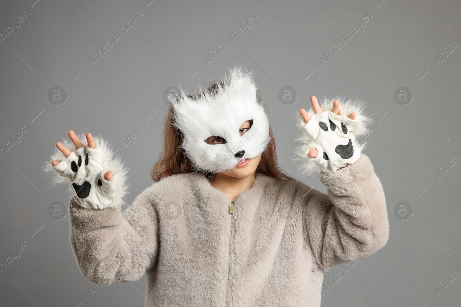 Photo of Quadrobics. Girl wearing cat mask and gloves on grey background