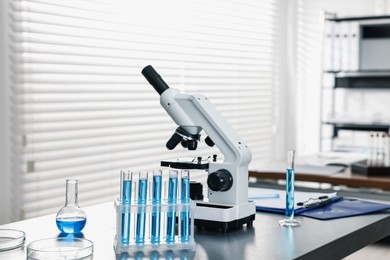 Photo of Chemical glassware and microscope on table in laboratory