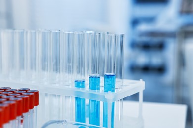 Photo of Test tubes with blue liquid on table in laboratory, closeup