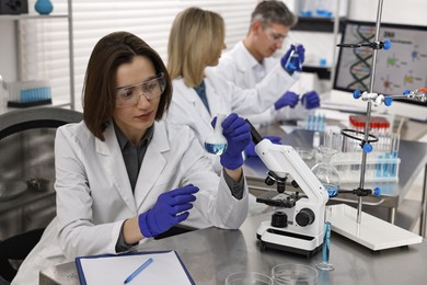 Photo of Scientist holding flask with sample in laboratory