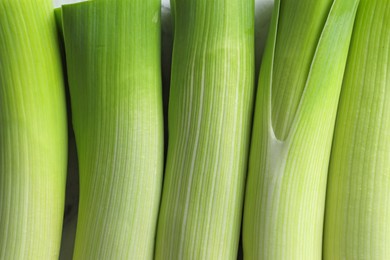 Photo of Whole fresh leeks as background, top view