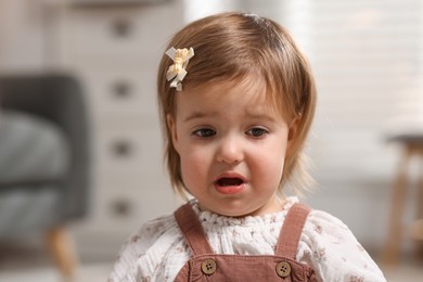 Photo of Portrait of sad baby girl at home