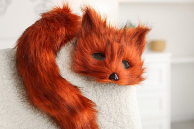 Photo of Quadrobics. Fox mask and tail on armchair indoors