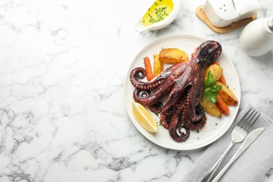 Photo of Roasted octopus with vegetables served on white marble table, flat lay. Space for text