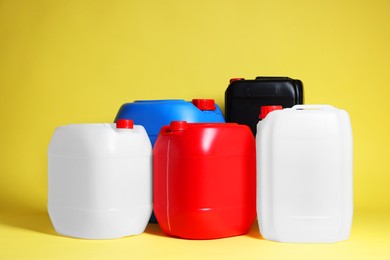 Photo of Many different plastic canisters on yellow background