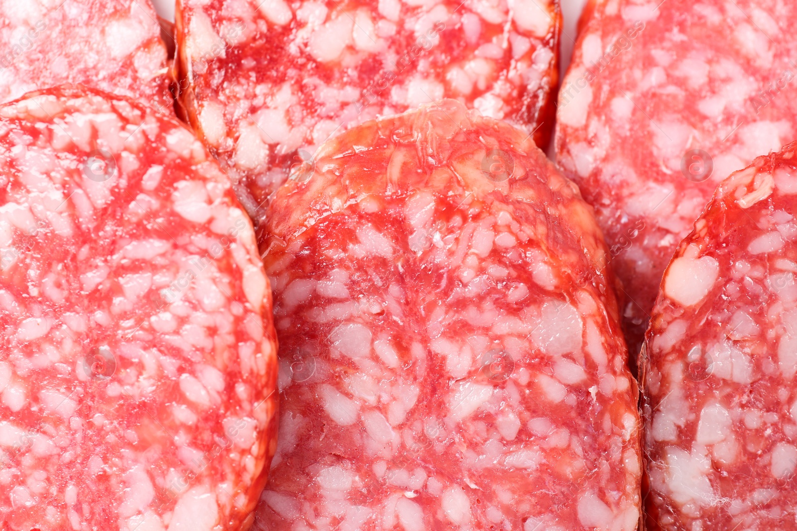 Photo of Pieces of tasty smoked sausage as background, closeup