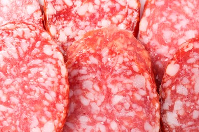 Photo of Pieces of tasty smoked sausage as background, closeup