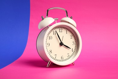 Photo of One white alarm clock on color background